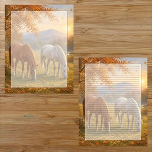 Puede incluir: Dos hojas rectangulares de papel de carta con una escena impresa de un caballo marrón y un caballo blanco pastando en un campo durante el otoño. Una hoja está en blanco, mientras que la otra contiene líneas horizontales, sobre un fondo de madera.