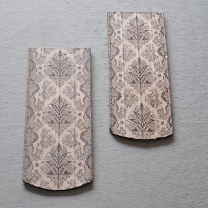 May include: Two decorative wall plaques with a white background and a brown floral pattern.