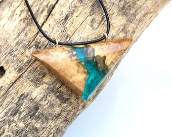 May include: A triangular pendant necklace with a wood and resin design. The resin is a vibrant teal blue color and the wood is a light brown color. The necklace is on a black cord.