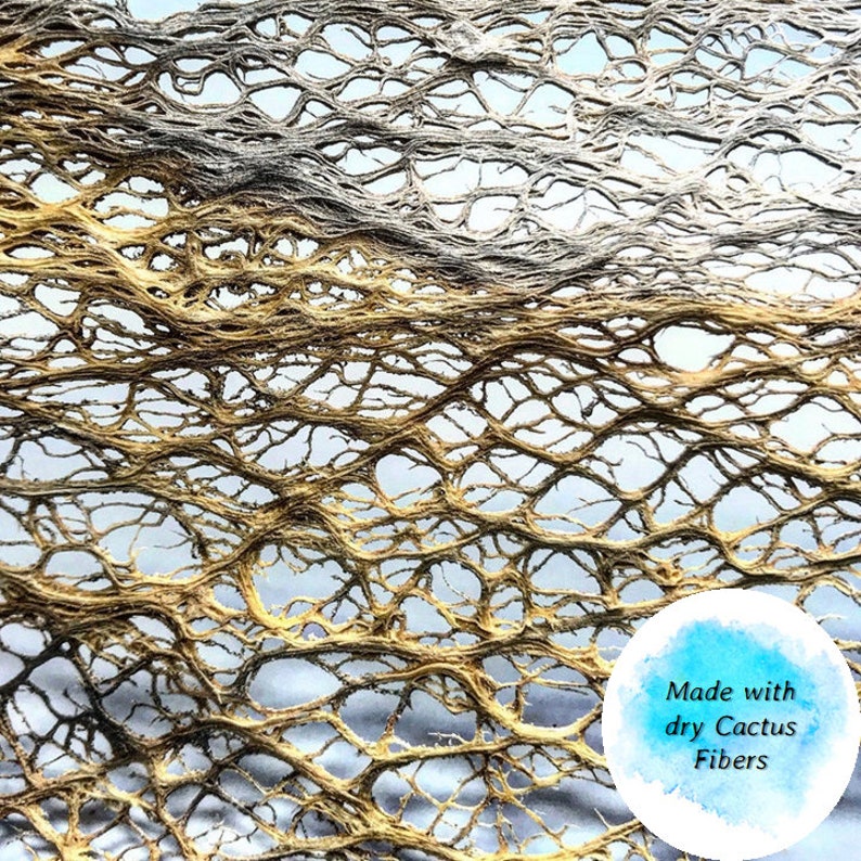 May include: Close-up of a woven material made with dry cactus fibers. The fibers are a light brown color and create a delicate, intricate pattern.
