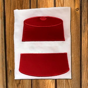 May include: Two red felt appliques in the shape of a fez, one with a rounded top and the other with a flat top.