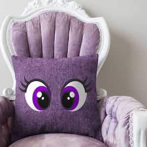 May include: A purple velvet chair with a white frame and a purple pillow with two large cartoon eyes with purple irises and black eyelashes.