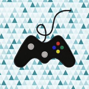 May include: A black video game controller with a cord. The controller has four colored buttons: red, blue, green, and yellow.