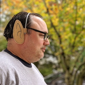 May include: A person wearing a pair of brown cardboard elf ears attached to a headband.