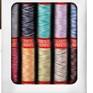 May include: A white box containing spools of colorful thread. The spools are arranged in two rows, with a variety of colors including teal, purple, and orange. Each spool has a red label with white text.