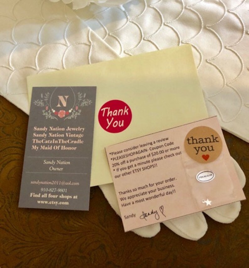 May include: Thank you card with a red heart and the text "Thank You" in a circle. The card also has the text "Please consider leaving a review. PLEASSHOPAGAIN - Coupon Code 20% off a purchase of $20.00 or more. If you get a minute please check out our other ETSY SHOPS!!" and "Thanks so much for your order. We appreciate your business. Have a most wonderful day!!" with a handwritten signature that says "Sandy".