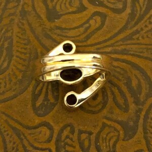 Peut inclure: Bague en or avec trois pierres pr&eacute;cieuses noires. La bague est con&ccedil;ue avec une bande torsad&eacute;e et une forme unique.