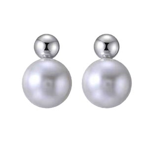 Puede incluir: Un par de pendientes de plata con dos perlas. Cada pendiente tiene una bola de plata más pequeña en la parte superior de una perla más grande.