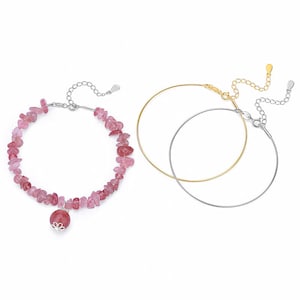 May include: Three bracelets on a white background. One bracelet features pink gemstone chips and a round pink charm. The other two are thin, circular, one gold-toned and one silver-toned, with adjustable clasps.