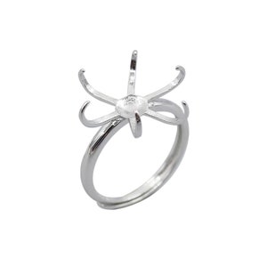 May include: Silver ring with a six-prong setting for a cabochon stone.