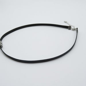 May include: A black choker necklace with a silver clasp and a silver chain detail.