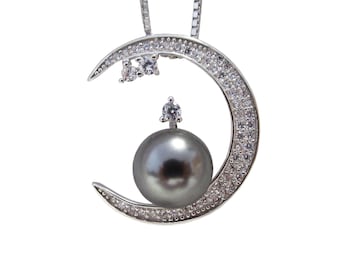 May include: A silver crescent moon pendant necklace with a black pearl and clear cubic zirconia stones.