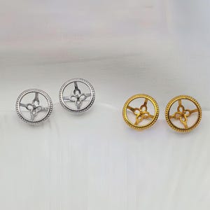 May include: Two pairs of circular earring settings, one pair in silver tone and one pair in gold tone. Each setting features a beaded outer rim and a central four-petaled floral prong structure designed to hold a gemstone or bead securely in place.