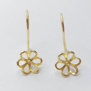 May include: A pair of gold-tone flower-shaped earring findings. The findings have a loop at the top for attaching to an earring hook and a small hole in the center for attaching a pearl or other gemstone.