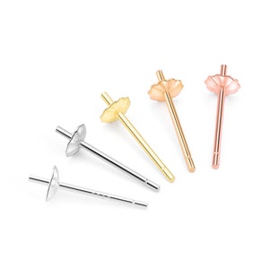May include: Four earring settings, two gold, one rose gold, and one silver. Each setting has a scalloped top and a straight post.