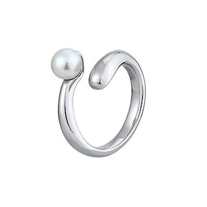 May include: A silver ring with a single white pearl on the side.
