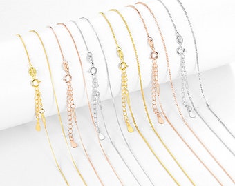 May include: A set of ten delicate chain necklaces in gold, silver, and rose gold. The chains are all the same style, but vary in length. Each chain has a small, round pendant at the end.