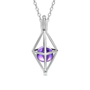 Könnte beinhalten: Eine silberne Halskette mit einem geometrischen Käfig-Anhänger, der einen violetten Amethyst-Stein enthält.