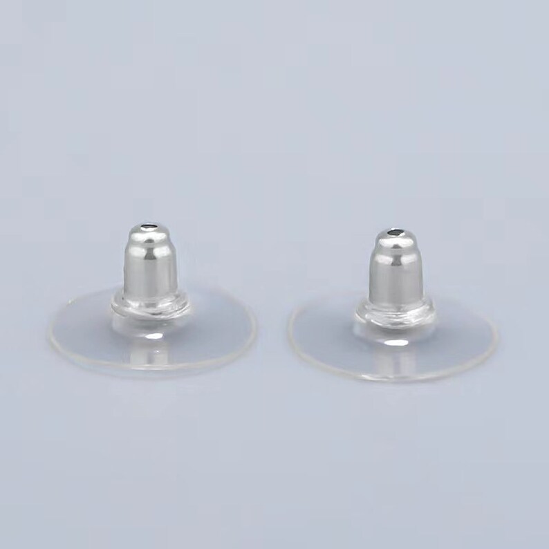 Puede incluir: Dos respaldos de pendientes de pl&aacute;stico transparente con postes de metal plateado. Los respaldos est&aacute;n dise&ntilde;ados para ayudar a mantener los pendientes en su lugar.