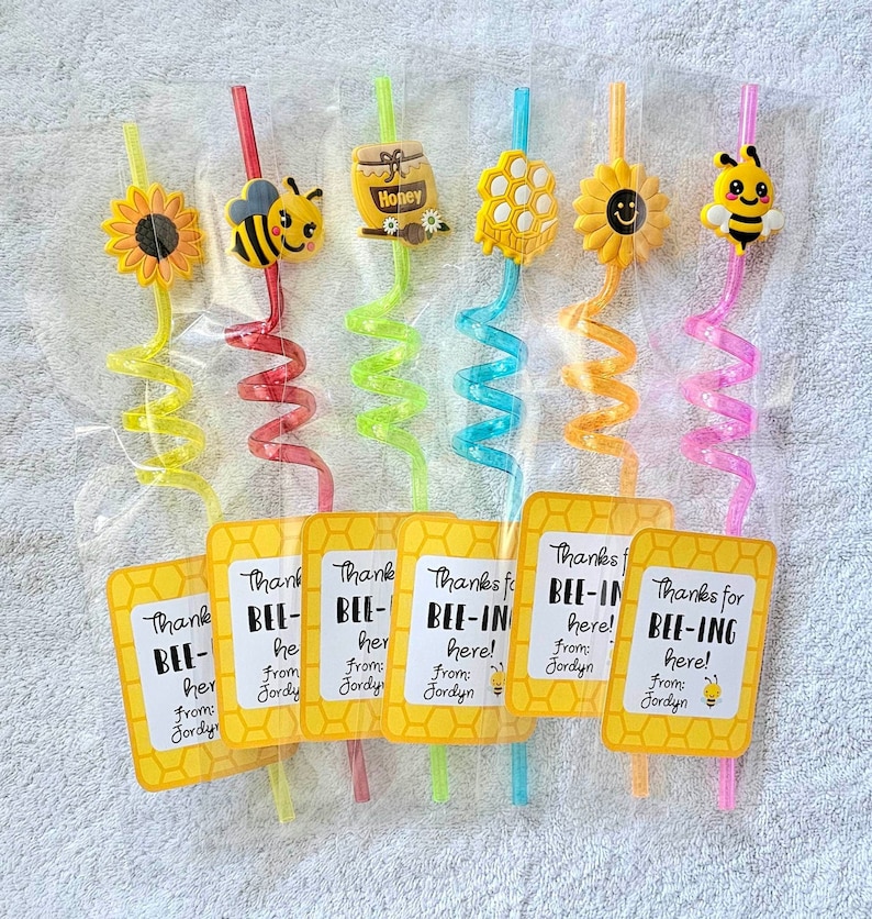 May include: Six colorful, bendy straws with bee-themed toppers and tags that say "Thanks for BEE-ING here! From: Jordyn". The toppers include a sunflower, a bee, a honey pot, a honeycomb, a smiley face, and a bee with wings.