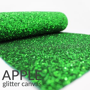 May include: Green glitter canvas fabric roll. The fabric is a bright, vibrant green with a fine glitter finish. The text "APPLE glitter canvas" is printed on the fabric.