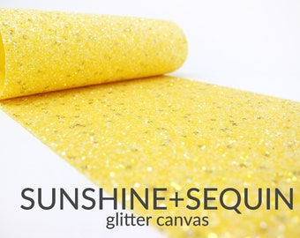 May include: A roll of yellow glitter canvas with the text "SUNSHINE+SEQUIN glitter canvas". The canvas is covered in small, sparkling sequins, creating a shimmering effect. The rolled portion is visible.