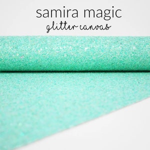 May include: A roll of turquoise glitter canvas fabric. The fabric is rolled out on a white surface. The text "samira magic glitter canvas" is printed above the fabric.