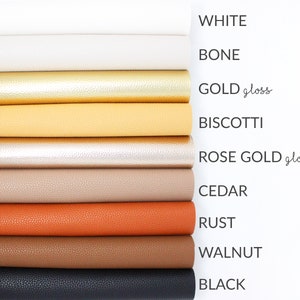 May include: A stack of ten different coloured faux leather sheets. The colours are white, bone, gold gloss, biscotti, rose gold gloss, cedar, rust, walnut, and black.