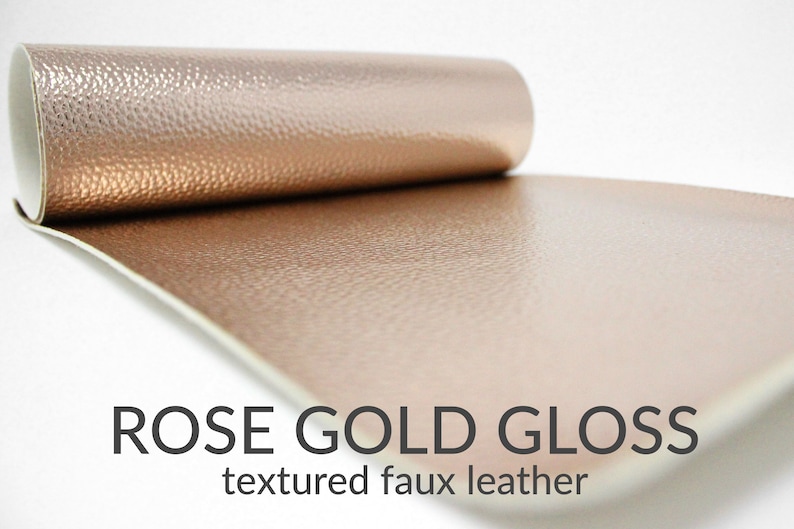 May include: A roll of rose gold gloss textured faux leather. The leather has a subtle pebbled texture.