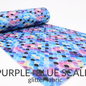 May include: Purple and blue glitter fabric with a scale pattern. The fabric is rolled up and the scales are visible.