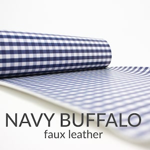 May include: A roll of navy blue and white gingham faux leather fabric. The fabric has a checkered pattern.