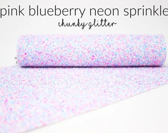 May include: A roll of white fabric with pink and blue glitter sprinkles. The fabric is called "pink blueberry neon sprinkles chunky glitter".