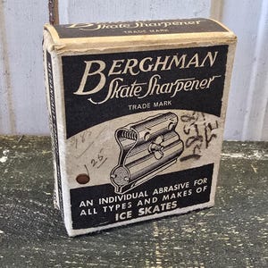 May include: Vintage Berghman Skate Sharpener box. The black and white box features the product name and an illustration of the sharpener. Text on the box reads "An Individual Abrasive for All Types and Makes of Ice Skates."