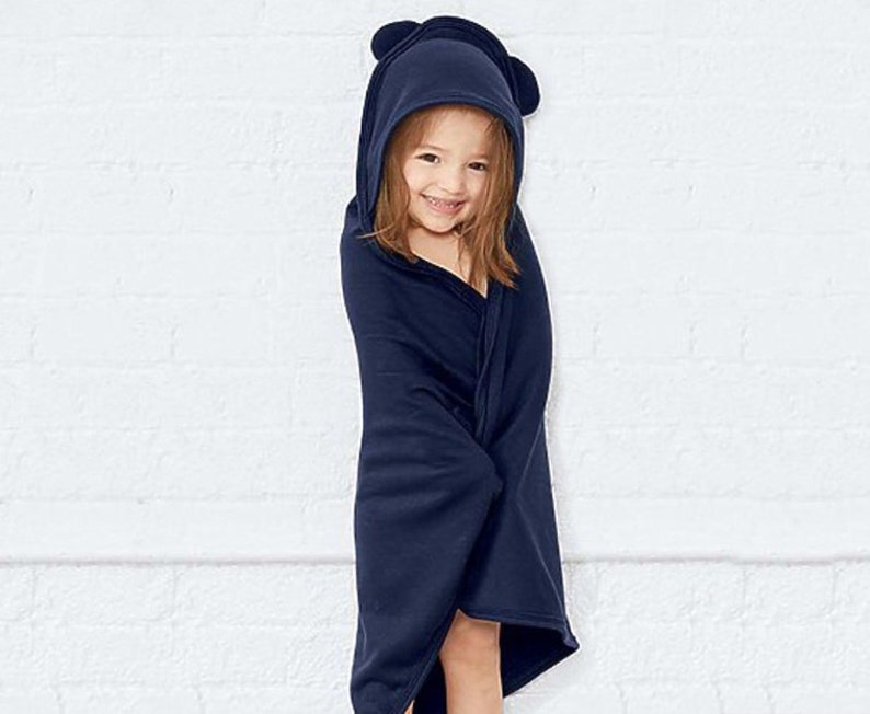 Peut inclure: Une serviette &agrave; capuche bleu marine avec des oreilles d'ours. La serviette est faite d'un mat&eacute;riau doux et absorbant, id&eacute;ale pour garder un enfant au chaud et au sec apr&egrave;s le bain.