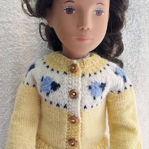 Sweaters for 16 inch dolls as pictured with a lamb motif. Created from a pattern by Kristin Maw.