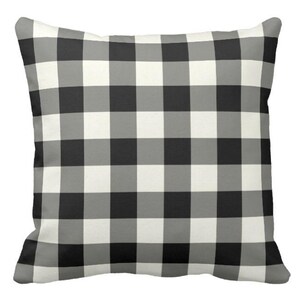 May include: Black and white checkered throw pillow. The pillow has a classic buffalo plaid pattern.