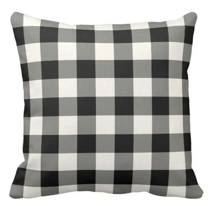 May include: Black and white checkered throw pillow. The pillow has a classic buffalo plaid pattern.