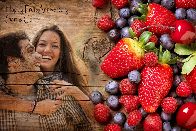 May include: A couple, Sam and Carrie, are pictured in front of a wooden background with a fruit border. The border includes strawberries, raspberries, blueberries, and a cherry.