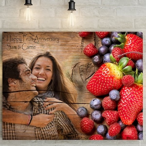 May include: A wooden canvas print with a photo of a couple and a fruit arrangement. The text "Happy Fruit Anniversary Sam & Carrie" is printed on the canvas.