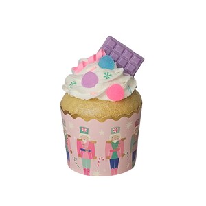 May include: A pink cupcake with white frosting and colorful sprinkles, topped with a purple chocolate bar. The cupcake is in a pink and white cupcake liner with a nutcracker design.