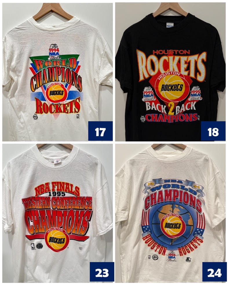 May include: Four vintage Houston Rockets t-shirts. The first shirt is white with red, green, and blue text that says "World Champions" and "Rockets". The second shirt is black with red, yellow, and white text that says "Houston Rockets" and "Back 2 Back Champions". The third shirt is white with red, yellow, and blue text that says "NBA Finals 1995 Western Conference Champions" and "Rockets". The fourth shirt is white with red, blue, and yellow text that says "World Champions" and "Houston Rockets".
