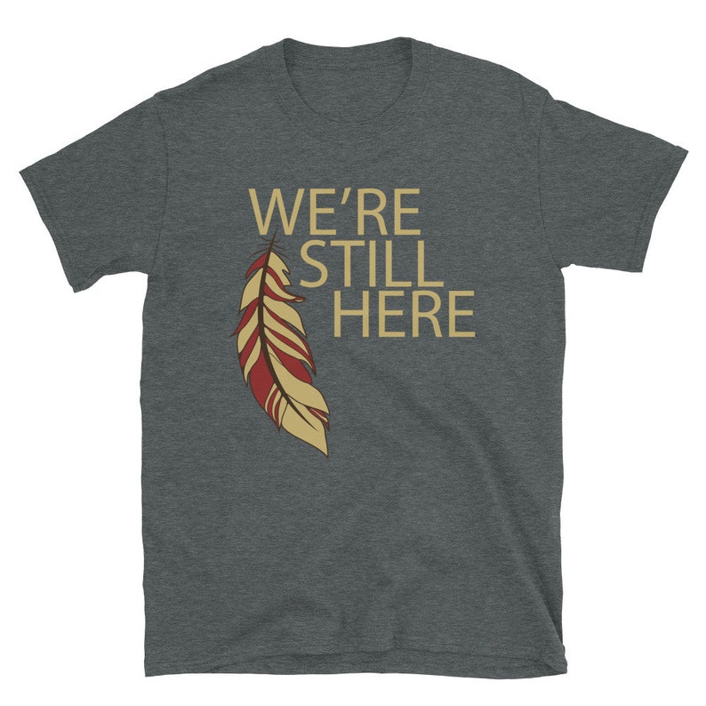 We're Still Here Feather Unisex T-shirts, Indigenous Pride, American Indian, Beige Text, Maroon, Brown Dark Heather