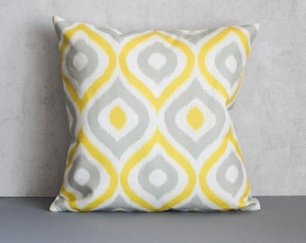 May include: A yellow and gray patterned throw pillow with a geometric design. The pillow is made of a soft, comfortable fabric and is perfect for adding a touch of style to any room.