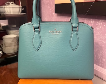 Bolso satchel “Tiffany’s” de Kate Spade en tono azul con correa de hombro desmontable.