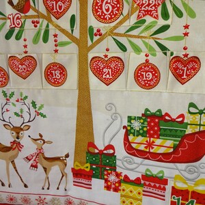 Puede incluir: Un calendario de adviento navide&ntilde;o con un &aacute;rbol, renos y un trineo lleno de regalos. El &aacute;rbol tiene 24 bolsillos numerados, cada uno con una abertura en forma de coraz&oacute;n. Los renos son marrones con lazos rojos y cuernos. El trineo es rojo con un borde blanco y est&aacute; lleno de regalos envueltos de colores.