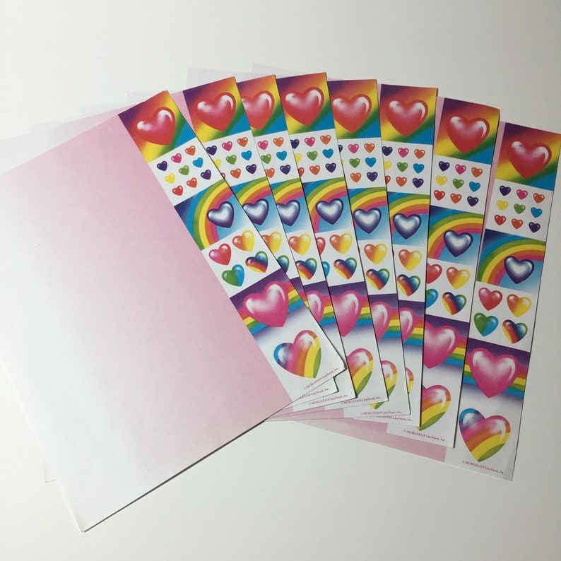 May include: A collection of heart-themed stickers with rainbow and pastel color schemes. The stickers feature large, glossy hearts, rainbows, and smaller heart designs. The stickers are arranged in strips and are next to a pink envelope.