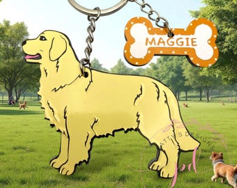 May include: A yellow Golden Retriever keychain with a bone-shaped tag that reads "MAGGIE". The dog is standing on a green lawn with trees in the background. The keychain is attached to a silver ring.