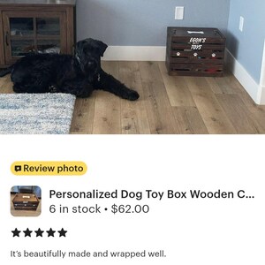 May include: A dark brown wooden crate with horizontal slats, featuring the white text "EGON'S TOYS" on the front panel, accompanied by a white bone graphic above the text and three white paw print graphics positioned below the text.