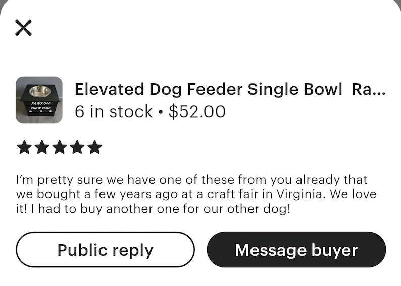 May include: A black elevated dog feeder featuring a single stainless steel bowl. The front panel of the wooden stand is printed with the white text "PAWS OFF" above the text "CHOW TIME" and includes a small white paw print graphic design.