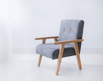Silla pequeña de bebé de color gris, un regalo para un niño.